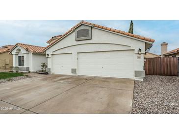 Attached two-car garage of a single-Gathering home with a traditional exterior and tile roof at 7543 E Keats Ave, Mesa, AZ 85209