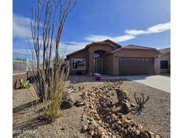 Single-story home features desert landscaping, covered entryway, and attached two car garage at 8965 E Red Mountain Ln, Gold Canyon, AZ 85118