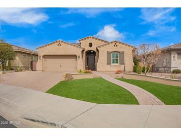 Charming single-story home featuring a two-car garage, desert landscaping, and a walkway leading to the front door at 9302 W White Feather Ln, Peoria, AZ 85383