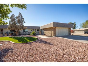 Charming single-story home featuring desert landscaping and an attached two-car garage at 9813 W Sandstone Dr, Sun City, AZ 85351