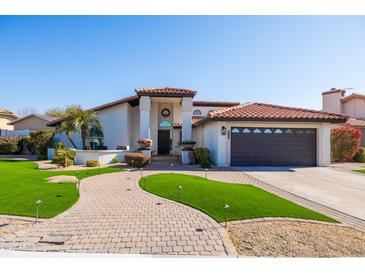 Inviting single-story home featuring manicured landscaping, a red-tile roof, and a covered front entryway at 1501 N Lesueur --, Mesa, AZ 85203