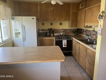 Charming kitchen featuring wooden cabinetry and countertops, and modern appliances at 2530 W Berridge Ln # E201, Phoenix, AZ 85017