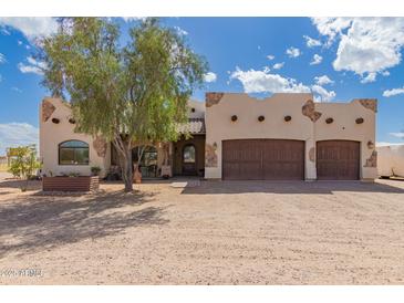 Charming home featuring a barrel tile roof, stone accents, and a spacious three-car garage at 27662 N Desert Sky Rd, Florence, AZ 85132