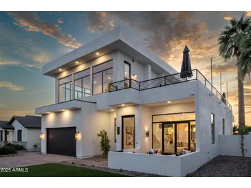 Elegant two-story home boasts a modern design, balcony, outdoor fireplace, and desert landscaping at 4120 N 44Th Pl, Phoenix, AZ 85018