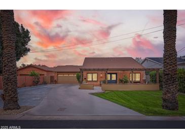 Charming single-story brick home featuring a well-manicured lawn, covered porch and a detached garage at 6314 N 14Th Pl, Phoenix, AZ 85014