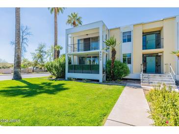 Inviting two-story condo with a well-manicured lawn and mature palm trees, creating a tranquil outdoor space at 6502 N Central Ave # A103, Phoenix, AZ 85012