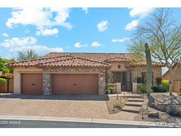 Charming single-story home with a tile roof, stone accents, three-car garage and desert landscaping at 7915 E Stonecliff Cir, Mesa, AZ 85207