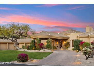Stunning home with desert landscaping, a circular driveway, and porte-cochere with a beautiful sunset backdrop at 9513 N 129Th Pl, Scottsdale, AZ 85259