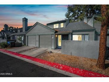 Charming two-story townhouse with a private two-car garage and well-maintained gray wood-clad exterior at 14002 N 49Th Ave # 1094, Glendale, AZ 85306