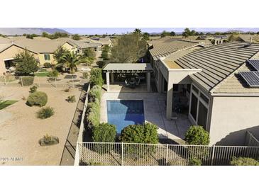 An aerial view of a private pool and pergola in the backyard of a well-maintained home at 19746 N Heron Ct, Maricopa, AZ 85138
