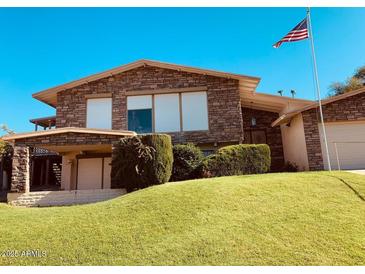 Charming two-story home featuring a stone facade and manicured front lawn with mature landscaping at 7532 N 23Rd St, Phoenix, AZ 85020
