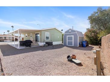 Spacious backyard with patio, BBQ, storage shed and desert landscaping for relaxing and entertaining outdoors at 7807 E Main St # Cc-98, Mesa, AZ 85207