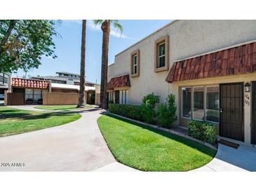 Charming townhouse featuring a well-manicured lawn and walkway leading to the front door at 1320 E Bethany Home Rd # 104, Phoenix, AZ 85014