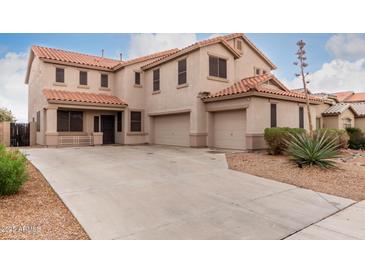 Inviting two-story home featuring a terracotta tile roof and three-car garage at 21622 N Backus Dr, Maricopa, AZ 85138