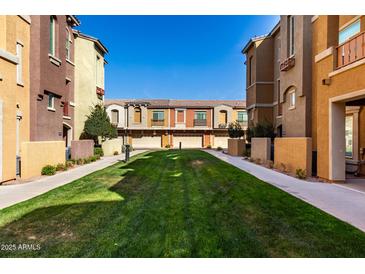 Inviting townhome community featuring a green lawn and well-maintained exteriors on a beautiful sunny day at 240 W Juniper Ave # 1146, Gilbert, AZ 85233