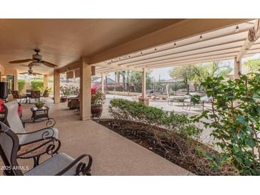 Inviting covered patio with ample seating and lush landscaping, perfect for outdoor relaxation and entertainment at 2612 N 161St Ave, Goodyear, AZ 85395