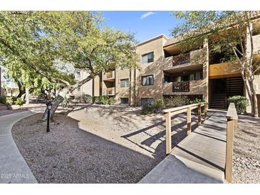 Condominium exterior featuring mature trees, landscaped grounds, walkways, and a bridge entry at 3031 N Civic Center Plz # 339, Scottsdale, AZ 85251