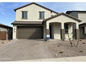 Two-story home featuring a brown tiled roof, a two-car garage, and a landscaped front yard at 43387 N Wollemi St, Queen Creek, AZ 85140