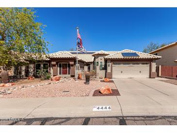 Charming single-story home featuring a tiled roof, desert landscaping, and a two-car garage at 4444 W Chama Dr, Glendale, AZ 85310