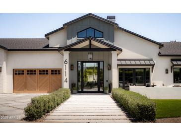 Stunning home featuring a covered front entry, manicured bushes and a striking front door at 6114 E Calle Del Norte --, Scottsdale, AZ 85251