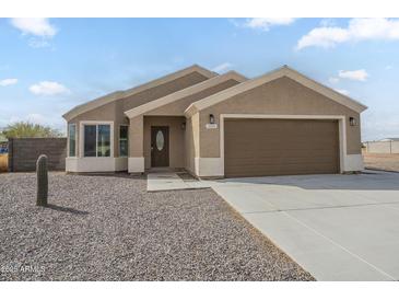 Charming single-story home with desert landscaping, a two-car garage and concrete driveway at 9965 W Devonshire Dr, Arizona City, AZ 85123