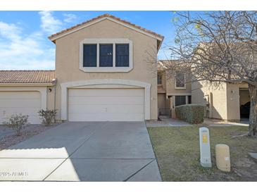 Two-story townhome featuring a two-car garage and well-maintained landscaping at 13824 S 41St Way, Phoenix, AZ 85044