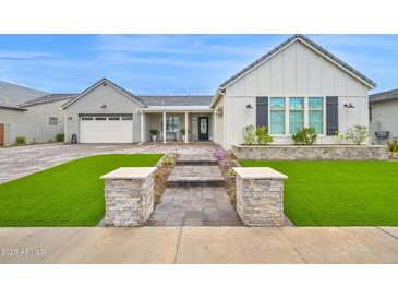 Charming single-Gathering home featuring a well-manicured lawn and a welcoming facade with stone accents and shutters at 1547 E Crescent Way, Gilbert, AZ 85298