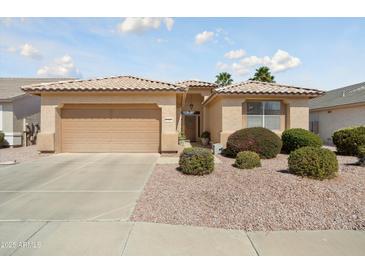 Charming single-story home with a well-manicured front yard and two-car garage, offering curb appeal at 17810 W Club Vista Dr, Surprise, AZ 85374