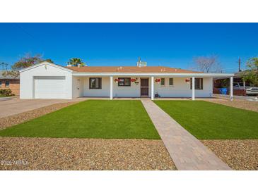 Charming single-story home with a manicured lawn, white exterior, and inviting front porch at 3028 E Highland Ave, Phoenix, AZ 85016