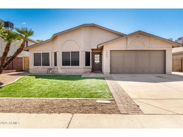 Charming single-story home featuring a well-manicured lawn, desert landscaping and attached two-car garage at 4041 W Cielo Grande --, Glendale, AZ 85310