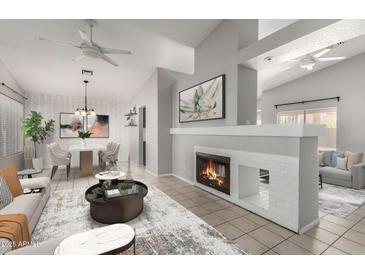 Bright living room featuring a fireplace, ceiling fan, modern decor, and adjoining dining area at 4041 W Cielo Grande --, Glendale, AZ 85310