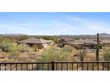 Desert backyard view overlooking neighboring houses and mountains on a sunny day at 42123 N Long Cove Way, Anthem, AZ 85086