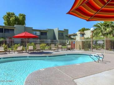 Community pool area featuring lounge chairs and patio furniture, perfect for relaxation and socializing at 4610 N 68Th St # 472, Scottsdale, AZ 85251