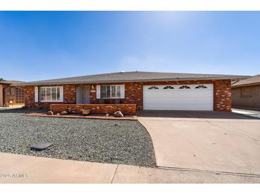 Charming brick home with a two-car garage, well-maintained gravel yard, and blue skies at 4619 E Farmdale Ave, Mesa, AZ 85206