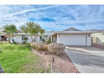 Charming single-level home with well-manicured lawn, mature landscaping, and a spacious two-car garage at 5223 W Acoma Dr, Glendale, AZ 85306