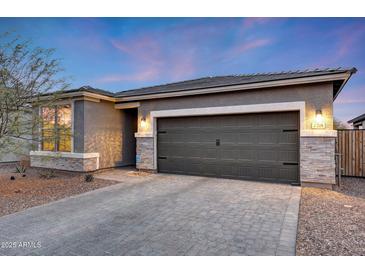 Charming single-story home with stone accents, a paver driveway, and a two-car garage creates a welcoming curb appeal at 738 W Kingman Dr, Casa Grande, AZ 85122