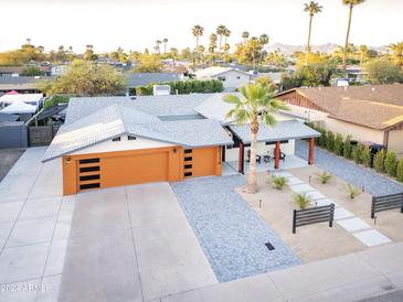 Expansive aerial view of a stylish home featuring a modern garage, desert landscaping, and mountain views at 8114 E Arlington Rd, Scottsdale, AZ 85250