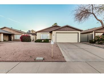 Charming single-story home with a well-maintained front yard and an attached two-car garage at 906 N Roosevelt Cir, Scottsdale, AZ 85257