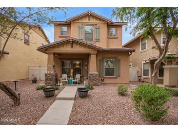 Charming two-story home with stone accents and inviting front porch with chairs at 1059 S Cheshire Ln, Gilbert, AZ 85296