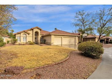 Charming single-story home featuring a well-maintained lawn and a spacious three-car garage at 12125 N 91St Way, Scottsdale, AZ 85260