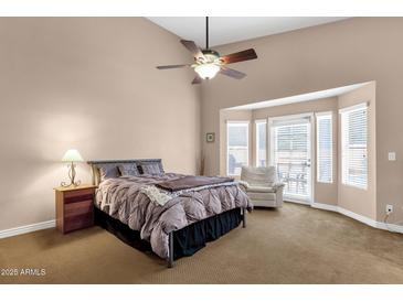 Spacious main bedroom featuring a ceiling fan and a cozy bay window seating area at 12125 N 91St Way, Scottsdale, AZ 85260