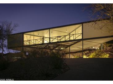 Striking modern home featuring an elevated design and expansive windows, beautifully lit at twilight at 1340 E Las Palmaritas Dr, Phoenix, AZ 85020