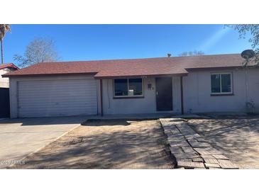Charming single-story home with a garage, and a pathway leading to the front door at 7231 W Turney Ave, Phoenix, AZ 85033