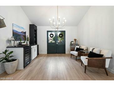 Bright living area featuring light wood flooring, white walls, stylish furniture, and modern decor with a chandelier at 9331 S Lakeshore Dr, Tempe, AZ 85284