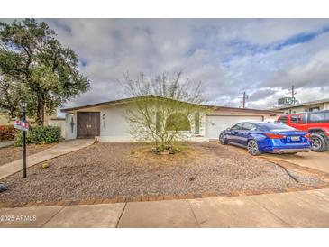 Charming single-story home with xeriscaped yard, mature trees, and a welcoming entrance at 1340 E Townley Ave, Phoenix, AZ 85020