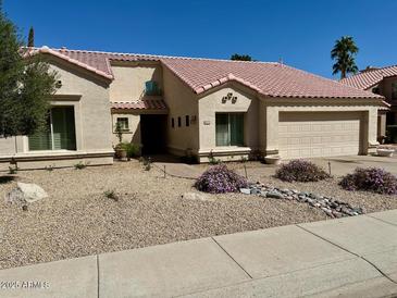 Charming single-story home featuring a desert landscape, red tile roof, and attached garage at 15273 N 92Nd Pl, Scottsdale, AZ 85260