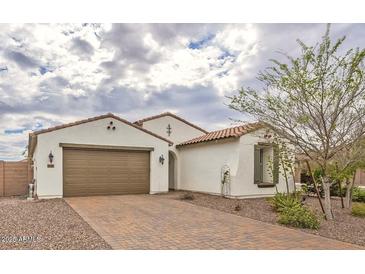 Charming single-story home features a brown two-car garage, terracotta roof, and a well-maintained brick driveway at 18385 W Devonshire Ave, Goodyear, AZ 85395