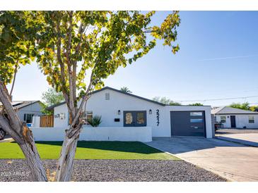 Charming exterior with modern design elements, including a sleek garage door and a well-manicured lawn at 2217 E Sheridan St, Phoenix, AZ 85006