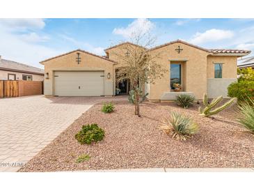 Charming single-story home showcasing desert landscaping, a brick driveway, and a neutral-colored stucco exterior at 3408 S 184Th Ln, Goodyear, AZ 85338