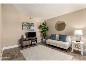 Cozy living room with neutral decor, a plush sofa, stylish furnishings and plenty of sunlight at 3511 E Baseline Rd # 1076, Phoenix, AZ 85042